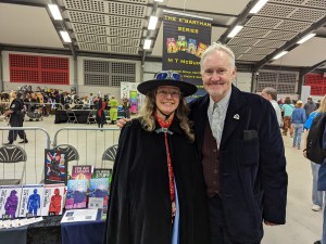 picture of two people smiling in front of a table at a sci fi convention