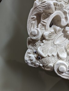 Picture of an ornate frame with eyes stuck on it so it looks like father Christmas